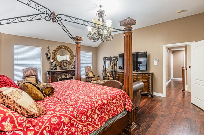 Bedroom featuring a chandelier, dark wood-style flooring, and vaulted ceiling | Image 21