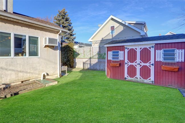 View of yard featuring a wall mounted air conditioner and a storage unit | Image 5