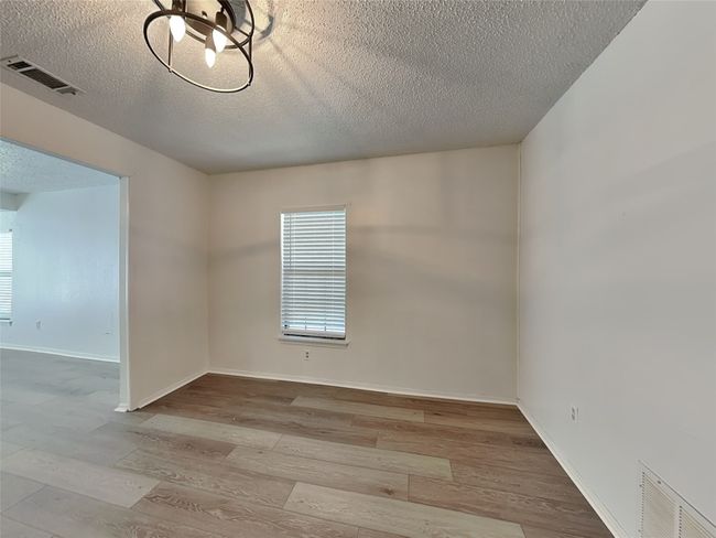 Unfurnished room featuring a textured ceiling, wood finished floors, and baseboards | Image 8