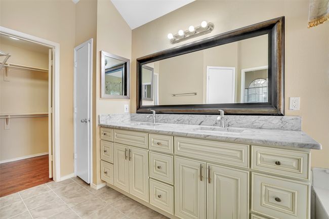 Bathroom featuring vanity with extensive cabinet space, dual sinks, and tile floors | Image 33
