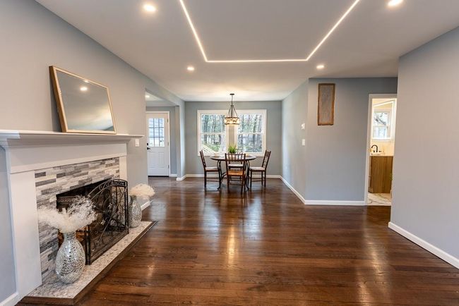 Dining space with dark wood-type flooring, baseboards, a stone fireplace, and recessed lighting | Image 33