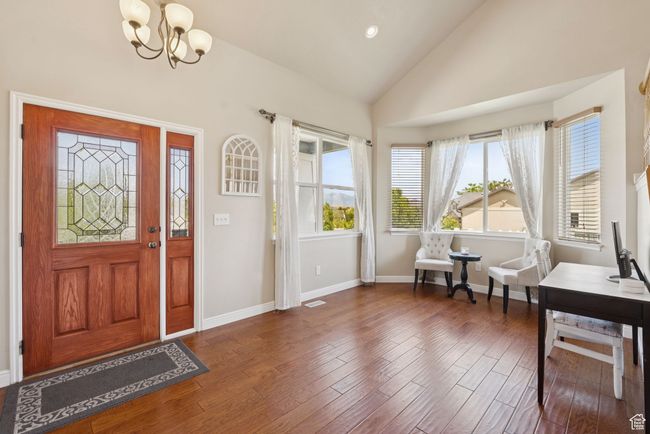 Entryway with a chandelier, wood finished floors, and high vaulted ceiling | Image 6