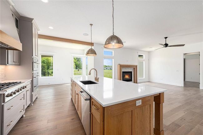 Kitchen with a sink, custom range hood, recessed lighting, light wood-style floors, and stainless steel appliances | Image 23