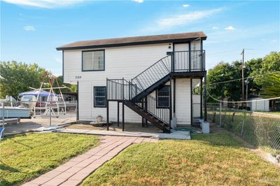 front view of property featuring a yard and a patio area | Image 1