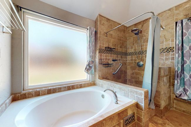 Bathroom featuring a tile shower and a garden tub | Image 24
