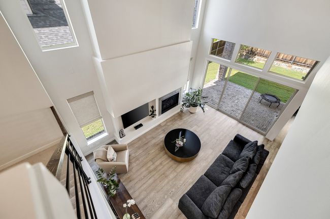 Living room with a fireplace, a towering ceiling, and wood finished floors | Image 36