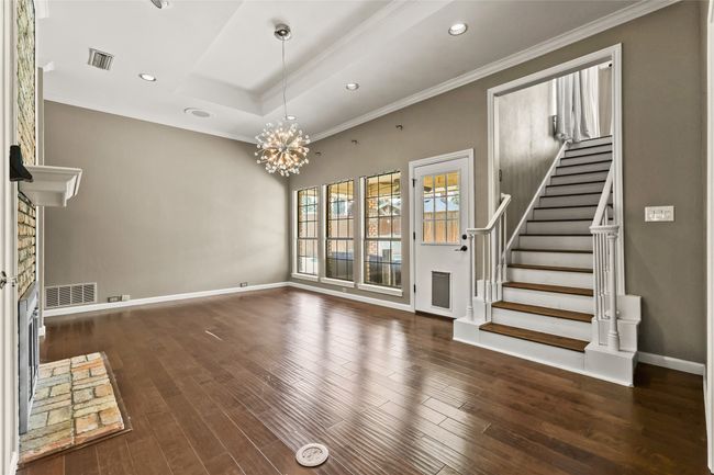 Unfurnished living room featuring stairway, ornamental molding, dark wood-type flooring, a chandelier, and recessed lighting | Image 10