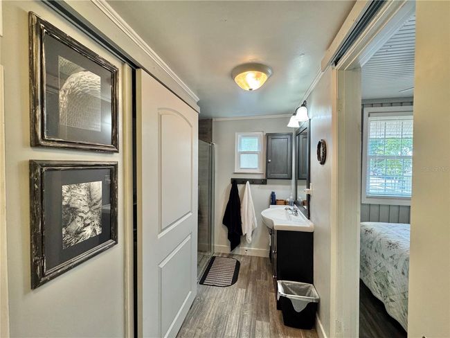 Primary full bathroom with stand up shower and barn door to cover laundry closet with stackable washer/dryer | Image 18