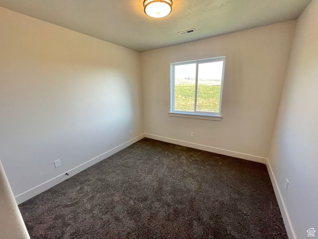 Empty room with baseboards, visible vents, and dark carpet | Image 11