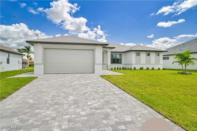 View of front of property featuring a front lawn and a garage | Image 1