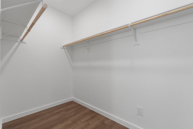 Walk in closet featuring dark wood-style​​‌​​​​‌​​‌‌​‌‌​​​‌‌​​‌‌​‌​​​​​‌ flooring | Image 6