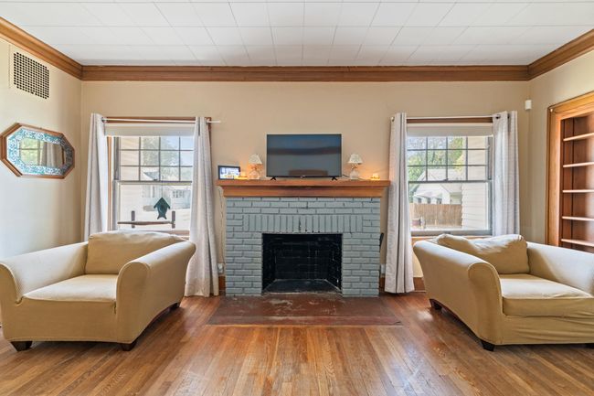 Living area featuring hardwood / wood-style floors, a brick fireplace, and ornamental molding | Image 24