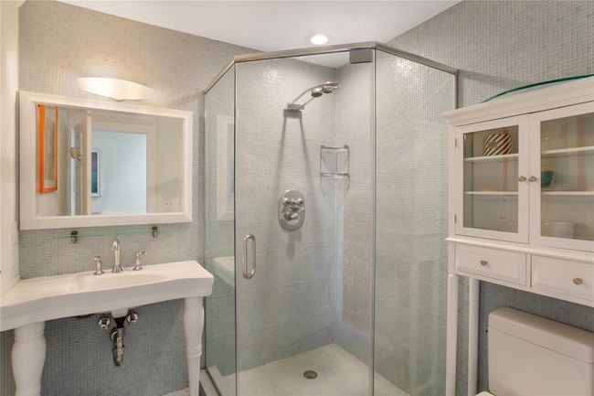 Full bathroom featuring tasteful backsplash, a stall shower, and toilet | Image 11