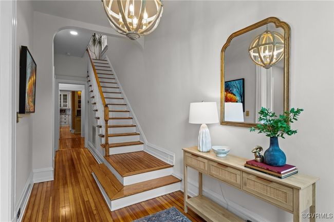 Staircase with recessed lighting, arched walkways, baseboards, hardwood / wood-style flooring, and a notable chandelier | Image 4