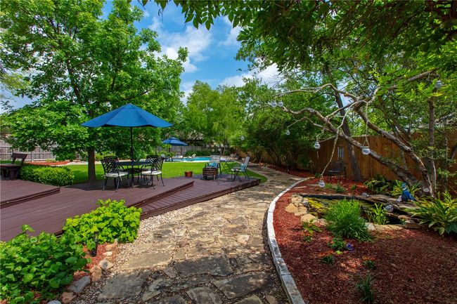 Surrounding community with a wooden deck, outdoor dining area, and a fenced backyard | Image 28