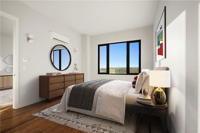 Bedroom with dark wood-type flooring and a wall mounted air conditioner | Image 4