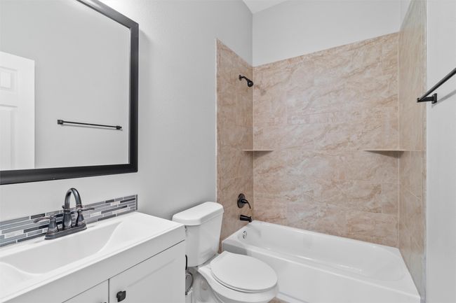 Full bathroom featuring tiled shower / bath, oversized vanity, and toilet | Image 16