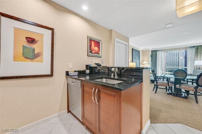 Kitchen featuring appliances with stainless steel finishes, dark countertops, brown cabinets, a breakfast bar, and recessed lighting | Image 22