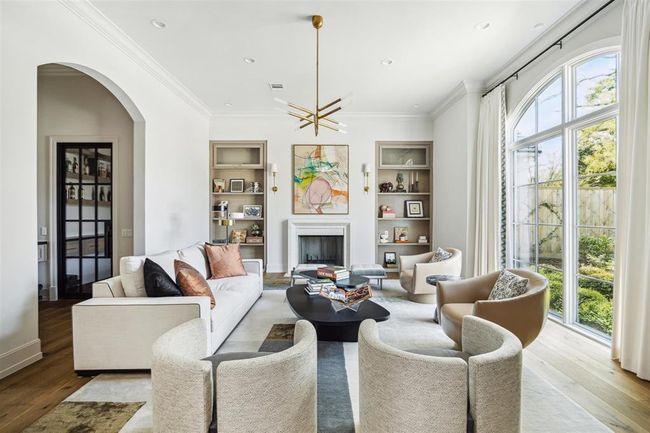 Overlooking the picturesque, tree-lined street, the light-filled formal living room or library radiates elegance with its wood-burning fireplace framed by a limestone mantel and beautiful white oak hardwood floors. Just steps away, an impressive wet bar is paired with a stunning, climate-controlled wine room—perfect for refined entertaining. | Image 4