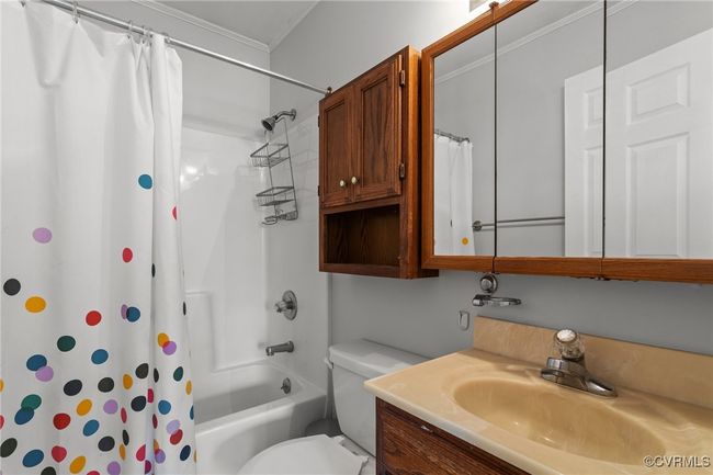 Full bathroom featuring toilet, crown molding, vanity, and shower / bath combo with shower curtain | Image 25