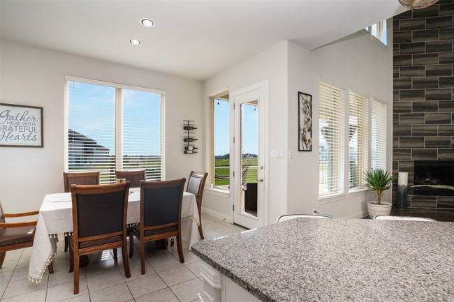 Dining area featuring a fireplace, baseboards, recessed lighting, and light tile patterned floors | Image 14