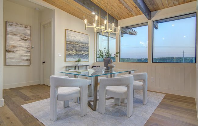 Dining area with wood finished floors, a chandelier, wooden ceiling with exposed beams, and baseboards | Image 8