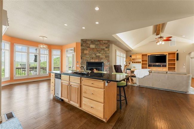 Kitchen featuring a sink, dark wood-style flooring, a fireplace, visible vents, and open floor plan | Image 20