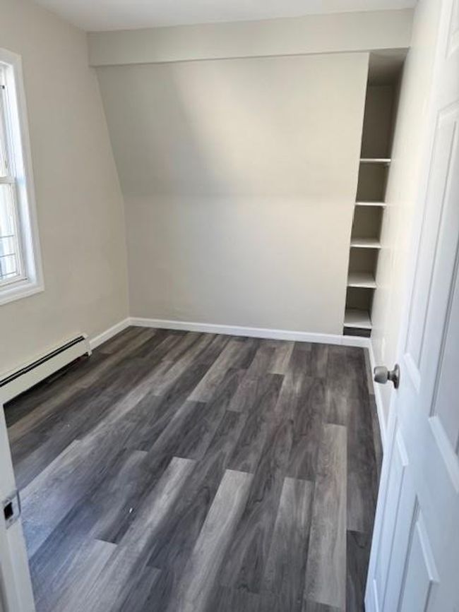 Bonus room with a baseboard heating unit, dark wood-style flooring, and lofted ceiling | Image 12