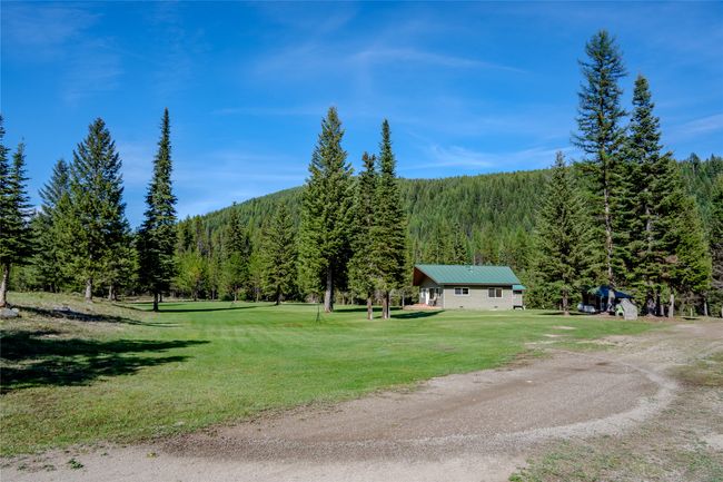 View of home's community featuring a wooded view and a yard | Image 61