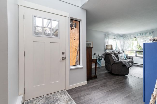 Foyer entrance with a baseboard heating unit, wood finished floors, and baseboards | Image 9