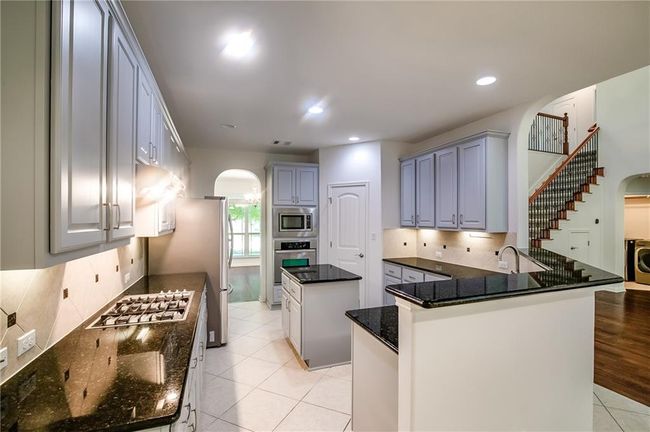 Kitchen featuring stainless steel appliances, arched walkways, backsplash, and recessed lighting | Image 12
