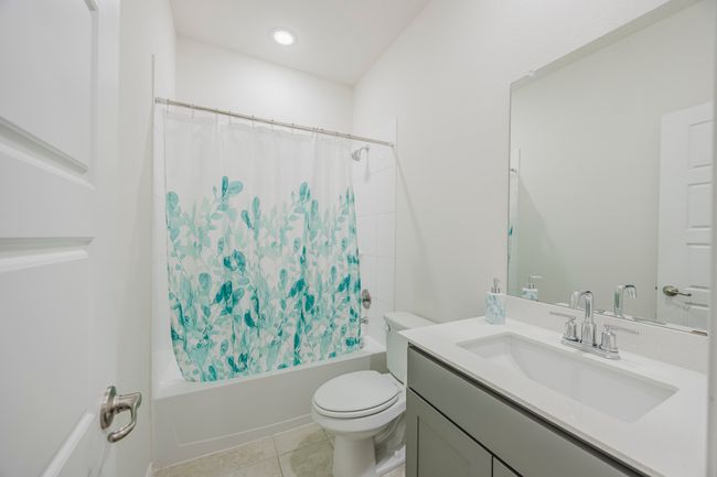Bathroom with vanity, shower / bath combo with shower curtain, and tile patterned floors | Image 22