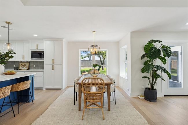 The dining area is perfectly positioned just off the kitchen, opening seamlessly into the living space. Large windows flood the area with natural light, creating an inviting setting for everyday meals or entertaining. | Image 14