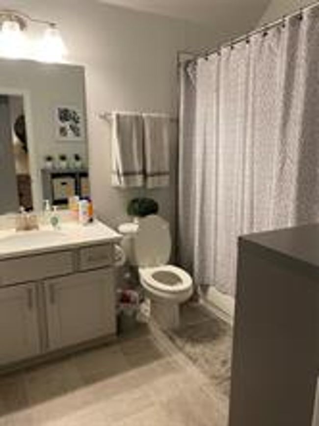 Bathroom with vanity, a shower with curtain, and tile patterned flooring | Image 19