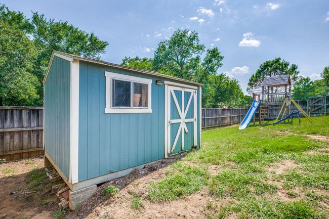 View of shed with a fenced backyard and a playground | Image 18