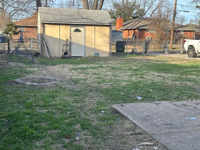 View of yard with a storage unit, fence private yard, and an outbuilding | Image 5
