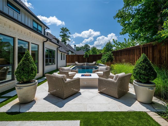 Fenced backyard with an outdoor fire pit and a patio | Image 35