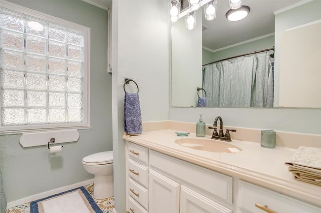 Full bath featuring crown molding, tile patterned floors, vanity, baseboards, and toilet | Image 26
