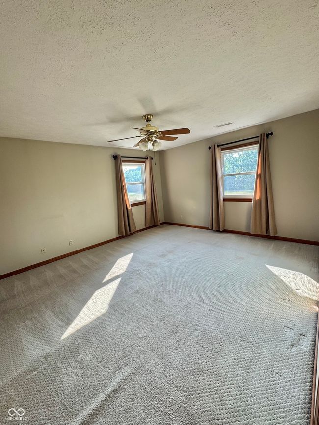 unfurnished room featuring light carpet, ceiling fan, baseboards, and a textured ceiling | Image 57