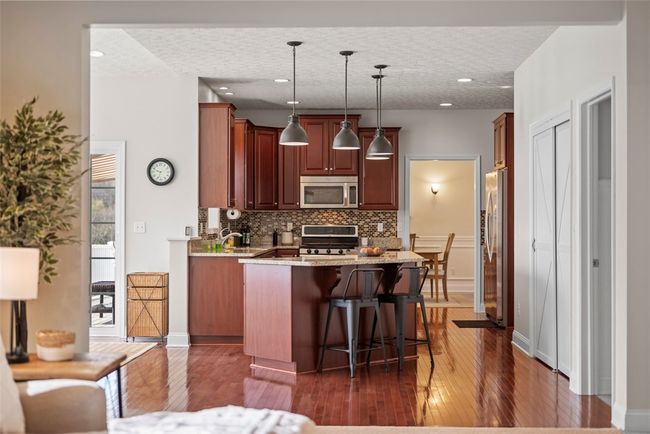 Dome pendant lights illuminate the kitchen island. | Image 13