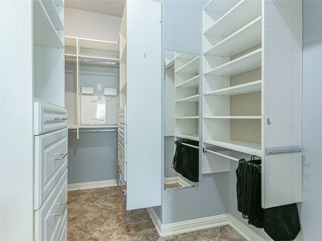 The primary closet has been upgraded with custom shelving and drawers for enhanced organized storage. | Image 16