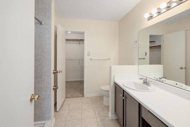 Full bath with a walk in closet, vanity, toilet, and tile patterned floors | Image 16