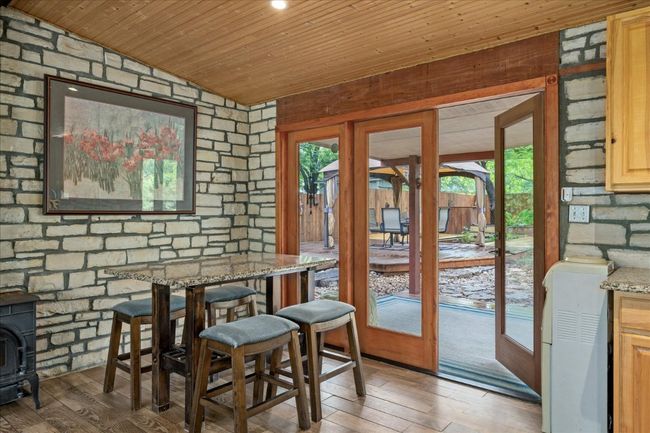 Dining space featuring wood ceiling, a wood stove, light wood-style floors, and lofted ceiling | Image 22