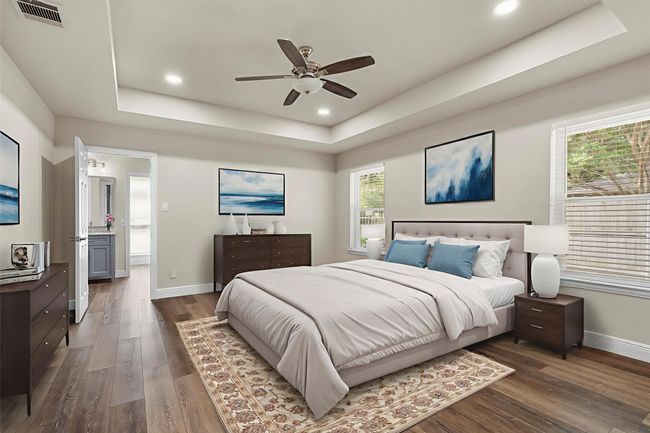 The spacious primary bedroom has a tray ceiling and is privately split from the other bedrooms. (This photo has been virtually staged to show it's potential.) | Image 19