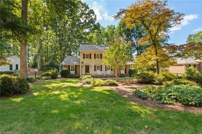 What a beauty! A two-story pier-columned front porch, off-center front door with glass and brass touches, graduated fenestration of the windows, over-the-door pediment detail, and beautiful landscaping that isn't fussy--it's just right. | Image 3