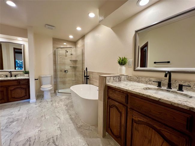 Full bath with a shower stall, two vanities, a soaking tub, recessed lighting, and marble finish floors | Image 11
