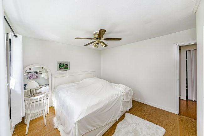 Bedroom with baseboards, a ceiling fan, and light wood finished floors | Image 11