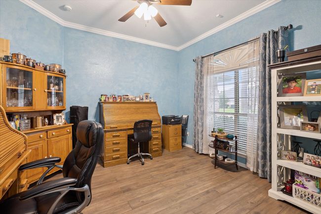 Home office featuring a ceiling fan, light wood look ceramic tile floors, and crown molding | Image 14