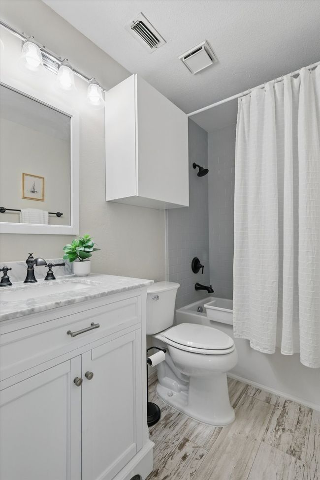 Bathroom featuring vanity, shower / bath combo, and wood finished floors | Image 24