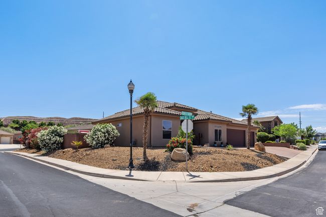 View of front facade with a garage, stucco siding, a tile roof, and driveway | Image 50